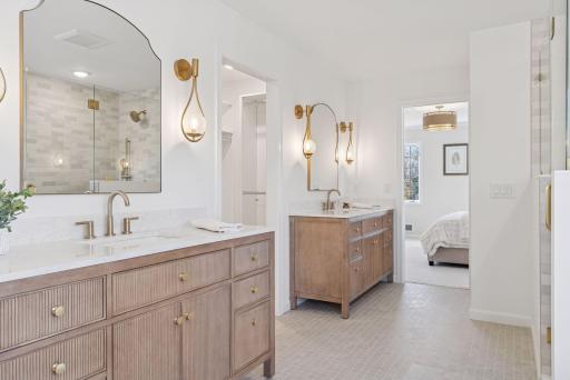 Indulge in the luxurious ensuite bathroom, featuring electric in-floor heating, elegant double sink vanities, and convenient access to the walk-in closet.