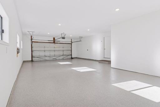 Three-car finished garage with gas heater, epoxy flooring, and rough-in for EV charger