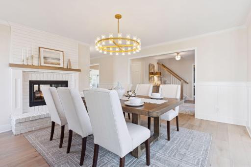 Step into this elegant dining room, featuring the other side of the charming double-sided wood-burning fireplace