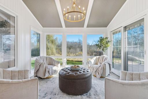 Relax in this inviting sunroom, once a three-season porch, now fully insulated and featuring elegant engineered French Oak flooring, with easy access to the Trex Select deck for seamless indoor-outdoor living.