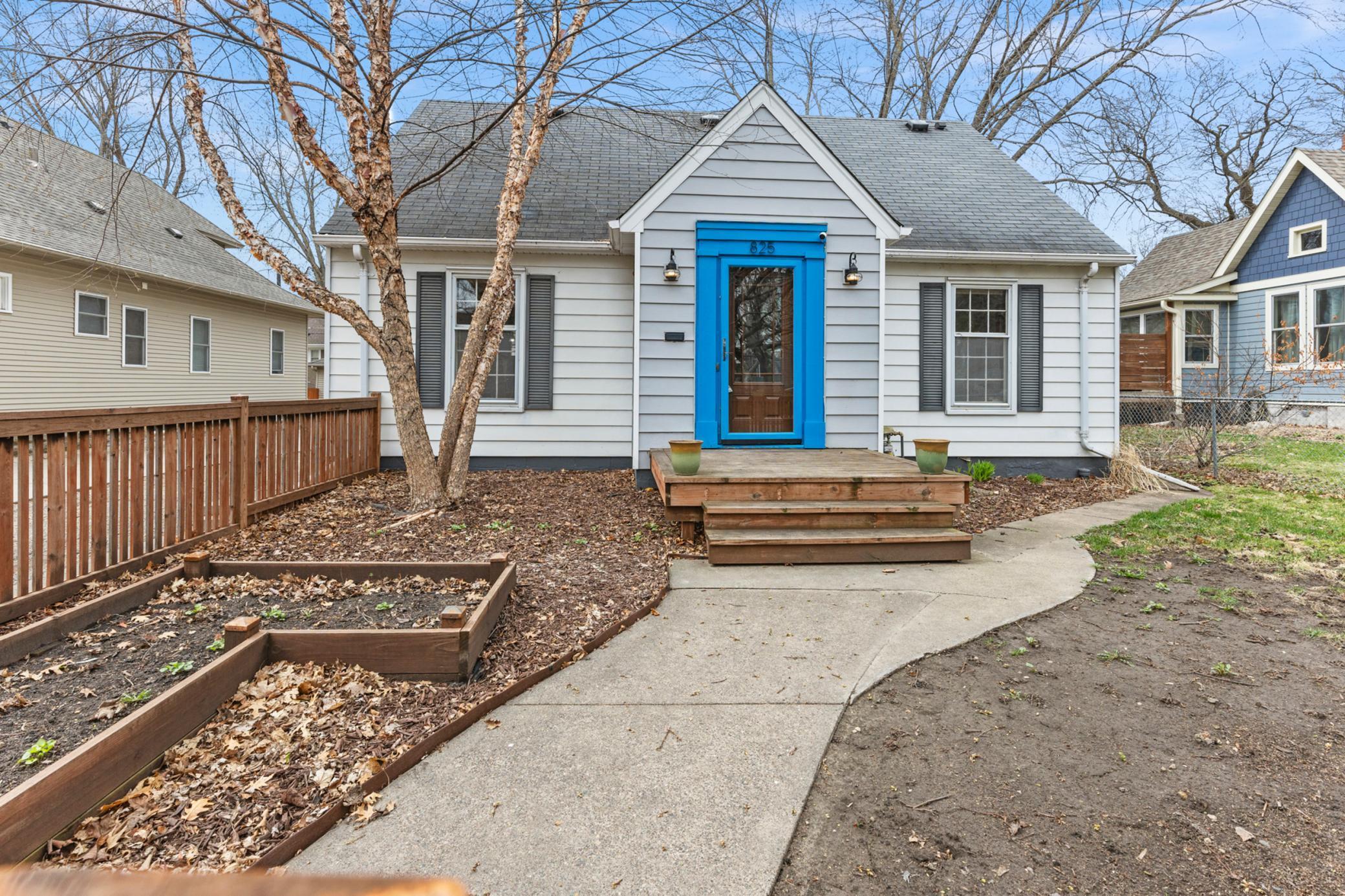 Nice curb appeal, with front deck, planter beds & birch tree.