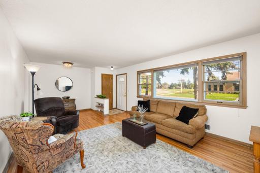 Main floor living room with gleaming hardwood floors and large front windows!