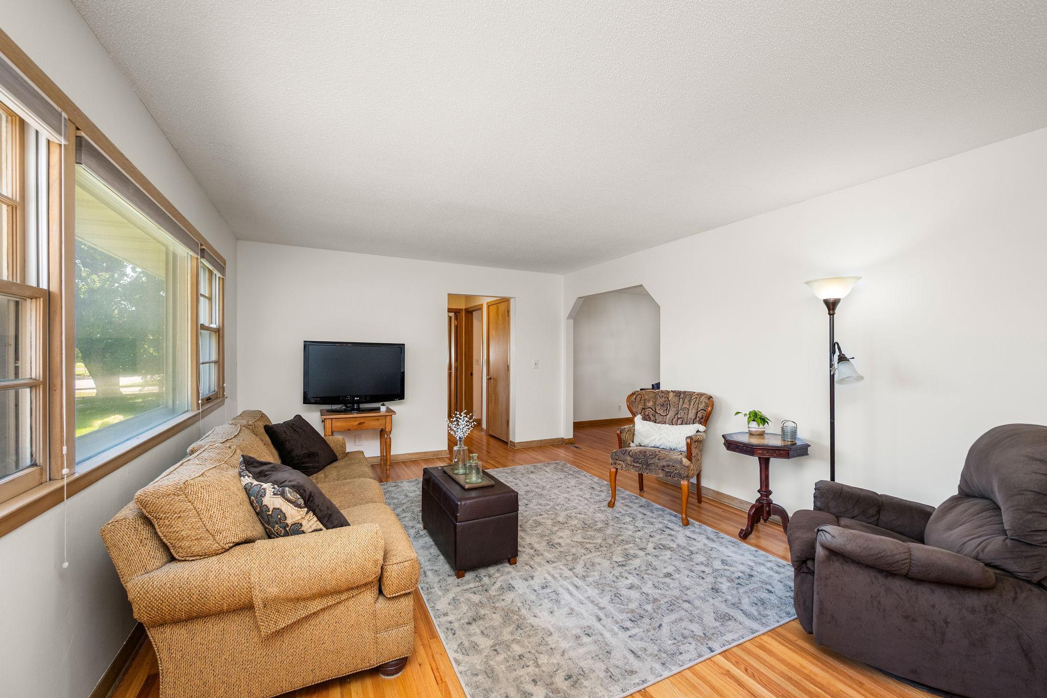 Main floor living room with gleaming hardwood floors and large front windows!
