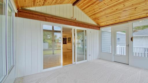 Interior view of three season porch. Doorway on right leads to backyard.