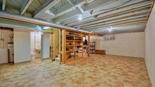 Lower level of home. Utility room on far left. Half bath next to utility room. Stairs leading back to the main level of the home.