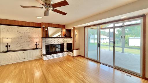 Gas burning fireplace with built in cabinets in the living room. Three season porch to the right.