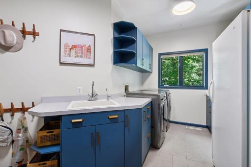Spacious laundry includes sink and a pop of color