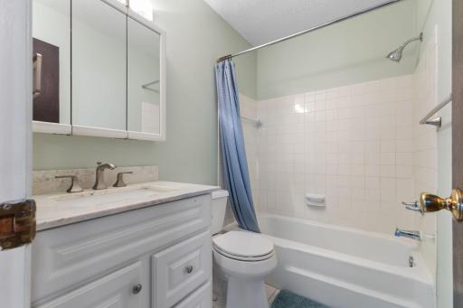 The full bathroom is easily accessible from both bedrooms and all other living areas, making it perfect for guests and everyday use. It features a crisp vanity with storage and a sleek hard-surface countertop.