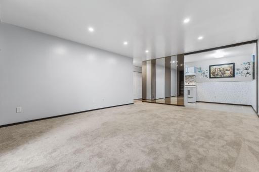 The living room is bright with natural streaming light and features neutral carpet and paint, ready for your own personal style.