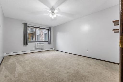 The primary bedroom is spacious with neutral tones, abundant natural light, and a ceiling fan for added comfort year round!