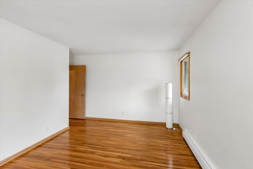 The large primary bedroom with beautiful hardwood floors.