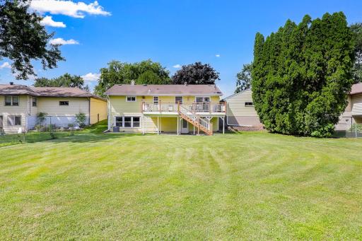 The large, flat, usable backyard has mature trees for partial privacy and provides plenty of open space for yard games and relaxation.