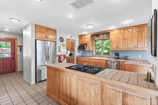 Kitchen has stainless steel appliance, tile countertop, slide in range with in floor exhaust and kitchen window.
