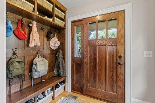 Front entry with beautiful wooden storage for hats, gloves and coats .
