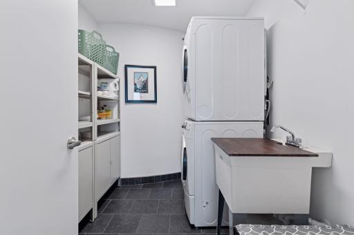 Spacious laundry area with storage and stacked units.