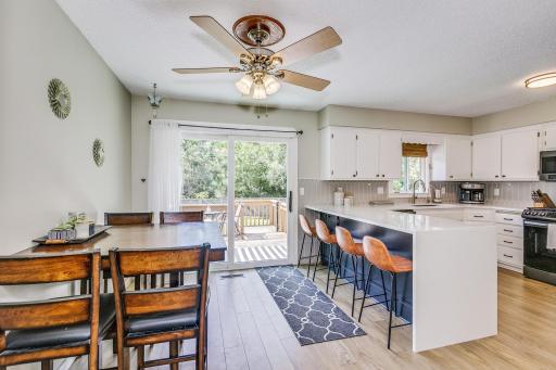 Kitchen and dining area lead onto deck overlooking pool and backyard.