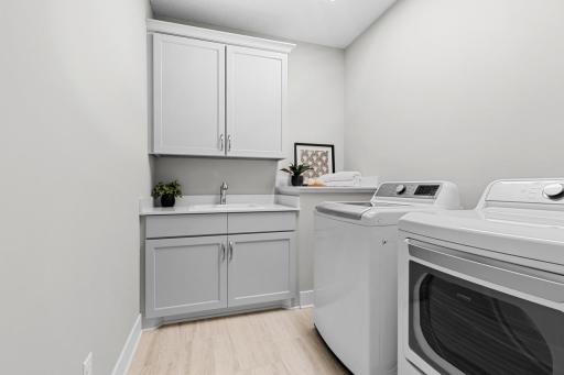 Laundry room with sink and cabinets for storage