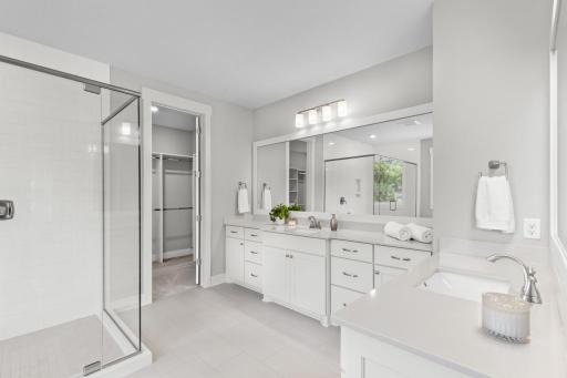 Primary bathroom features a spa-inspired ensuite bath with soaking tub, walk-in shower, and spacious walk-in closet