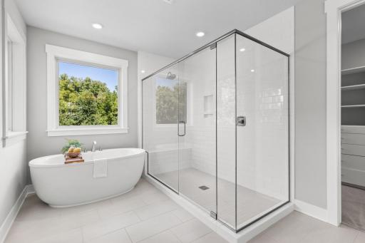 Primary bathroom features a spa-inspired ensuite bath with soaking tub, walk-in shower, and spacious walk-in closet
