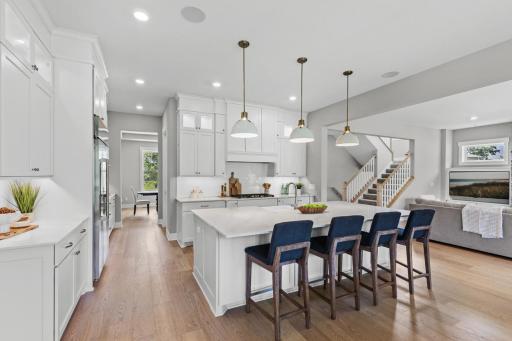 The crisp custom white cabinetry pairs seamlessly with the warmth of the hardwood floors