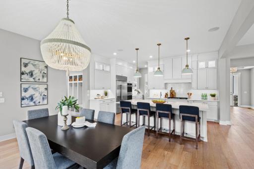 An informal dining area seamlessly connects to the kitchen, highlighted by an elegant lighting centerpiece