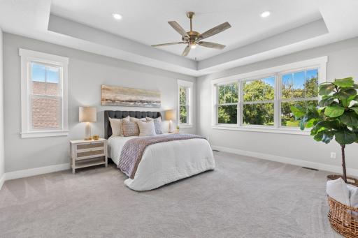 A bright and airy primary suite offers generous space and plenty of sunlight