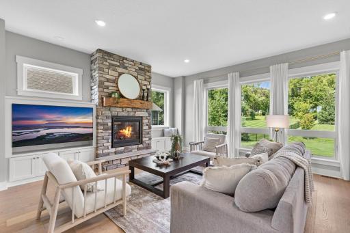 Flooded with light from floor-to-ceiling windows, the living space centers around a beautiful fireplace.