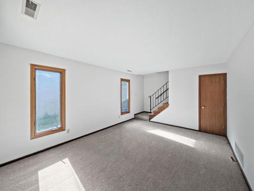 Spacious living room with fresh carpet and paint, ready for your touch to make it home!