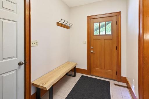 This entry is designed to keep shoes, jackets, and everyday essentials organized, directly connected to the attached garage and complete with a separate coat closet for added storage.