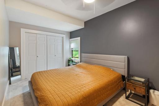 Main floor primary bedroom features a large closet with double doors, and a bright window overlooking the yard.
