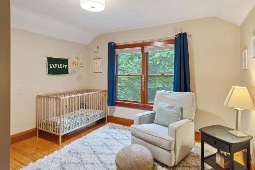 upper-level bedroom with hardwood floors, a large window for natural light, and ample space for a nursery or guest room.