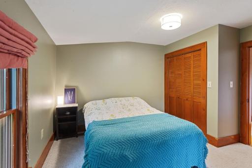 Another view of the upper-level guest bedroom showcasing a spacious layout with a large closet. A comfortable and versatile space for family or visitors.