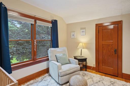 Another angle of the upper-level bedroom highlighting the original wood trim, and cozy layout.