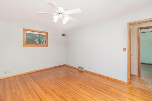 Bedrooms on the main floor feature refinished oak floors & ceiling fans.