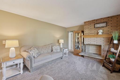 The main level is warm and inviting, beginning with a spacious living room anchored by a striking masonry brick fireplace.