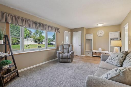 The main level greets you with a spacious living room featuring a large bay window that fills the space with natural light.