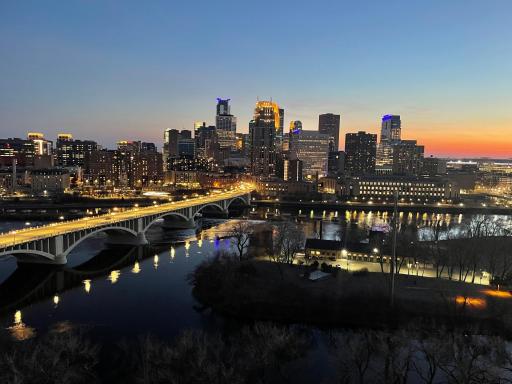 Front-row Minneapolis skyline glowing at twilight.