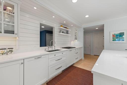 The kitchen features a cooktop. double ovens, and a pantry