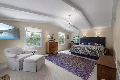 Primary suite sleeping area with vaulted ceiling