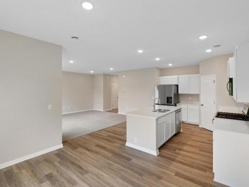Dining Room and Kitchen. Photo taken of another home with similar plan and finishes. Photos and renderings may not depict actual plan, materials, & finishes may vary. All measurements are approximate.