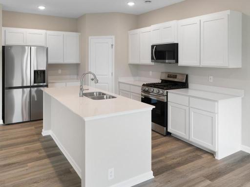 Kitchen. Photo taken of another home with similar plan and finishes. Photos and renderings may not depict actual plan, materials, & finishes may vary. All measurements are approximate.