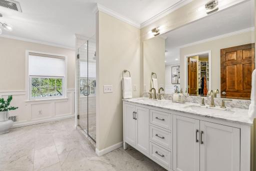 Updated primary bathroom with double sink vanity and walk in shower