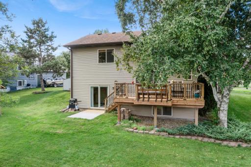 The backyard includes both a deck and a concrete patio.