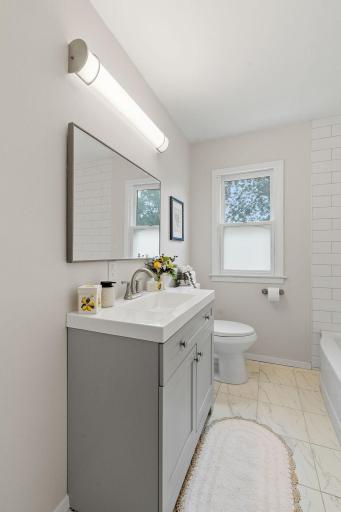 Updated bathroom featuring a new vanity, toilet, and fixtures.