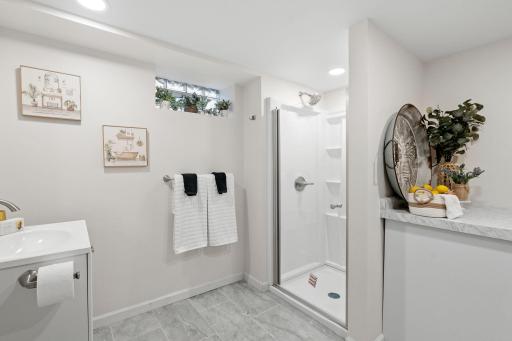 Modern bathroom design with a new standing shower and added cabinetry for storage.