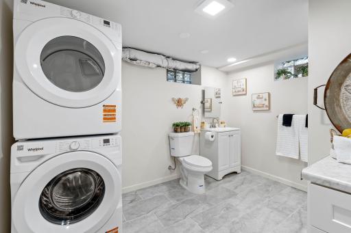Completely updated lower-level bathroom featuring new washer and dryer, sink, and toilet.