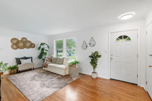 Sun-filled living room showcases rich hardwood floors and large windows that invite natural light.