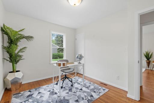 Comfortable secondary bedroom with hardwood flooring and natural light from the windows.