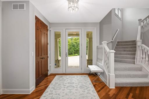 A spaciuos foyer with hardwood floors, 8' doors, 9' ceilings and a grand turned staircase