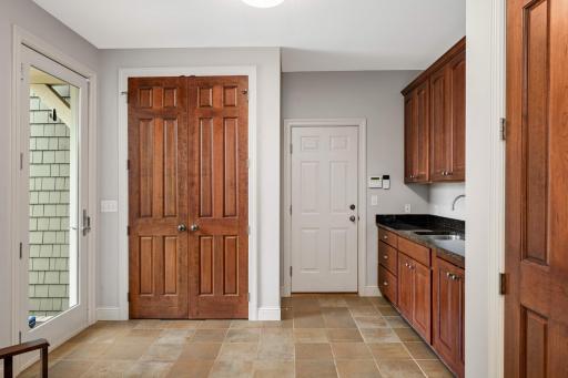 Large mudroom with a service door to the front and a door to the heated 3 car garage